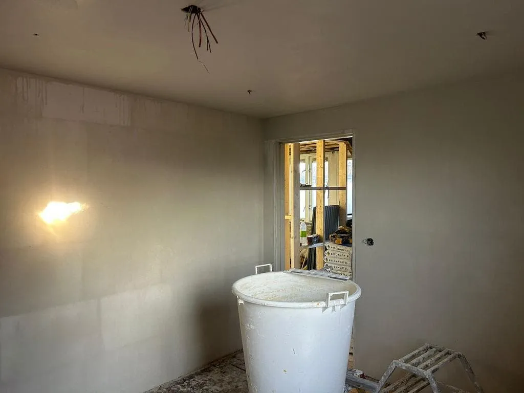 Woonkamer met vers gestuukte wanden en plafond in Bilthoven
